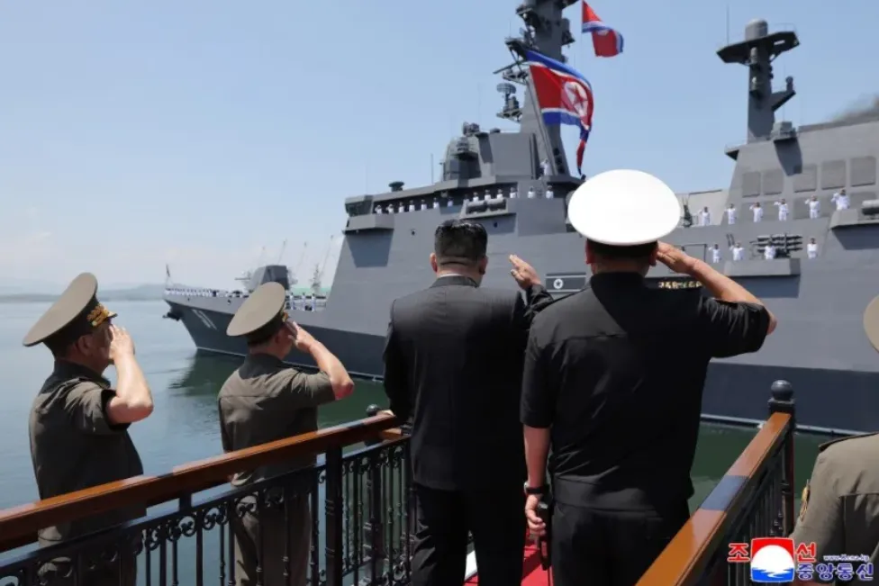 Pemimpin Korea Utara Kim Jong Un, di tengah, memberi hormat bersama para pemimpin militer saat kapal perusak Choe Hyon diresmikan.