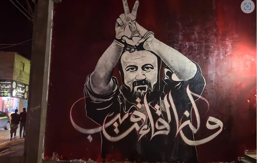 Seniman Palestina mengerjakan mural yang menggambarkan pemimpin Fatah yang dipenjara, Marwan Barghouti, di kamp pengungsi Jabalia di Jalur Gaza utara pada 13 April 2023.