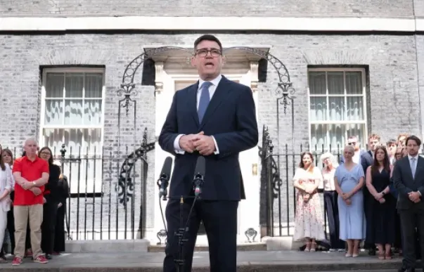 Perdana Menteri Inggris yang baru, Andy Burnham, berbicara pada staf dan wartawan di depan kantornya.