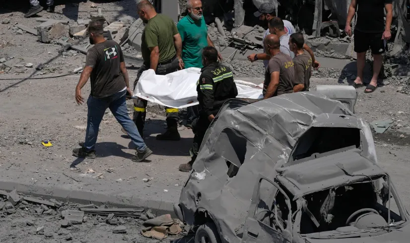 Petugas penyelamat membawa jenazah korban serangan udara Israel di Deir al-Zahrani, Lebanon, pada hari Sabtu.
