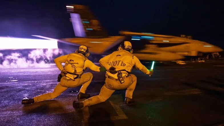 Pesawat tempur F-18 diluncurkan dari kapal induk.