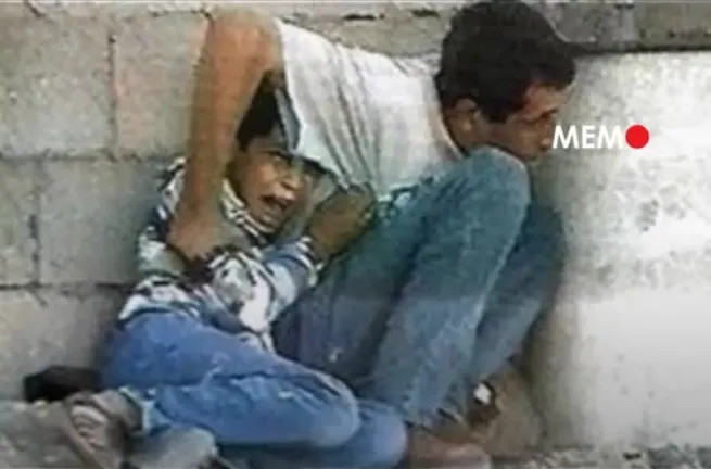 Muhammad al-Durra dan ayahnya terekam kamera sedang berlindung di balik blok beton di salah satu jalan di Gaza saat tentara Israel menghujani mereka dengan tembakan gencar pada 30 September 2000.