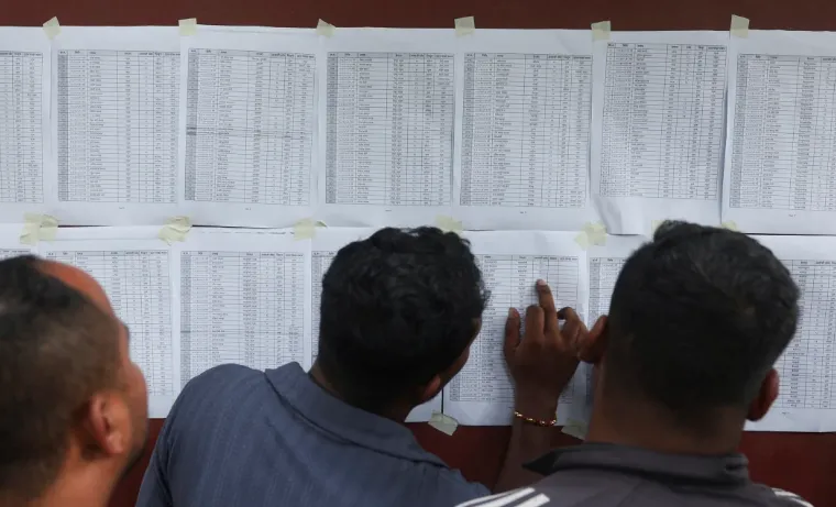 Orang-orang melihat daftar korban selamat di luar pusat pelatihan militer Barak Maithili, setelah banjir bandang dan tanah longsor, di Nuwakot, Nepal, 28 Agustus.