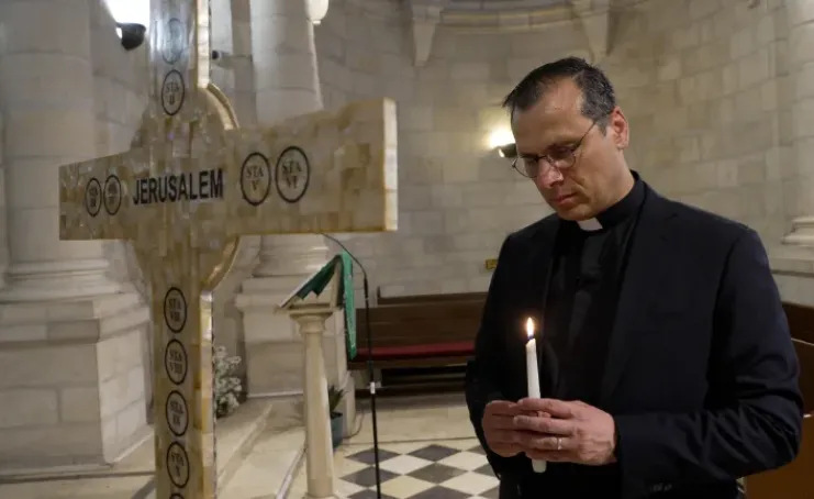 Pastor Munther Isaac menyalakan lilin dan berdoa di dalam Gereja Lutheran Natal Bethlehem.