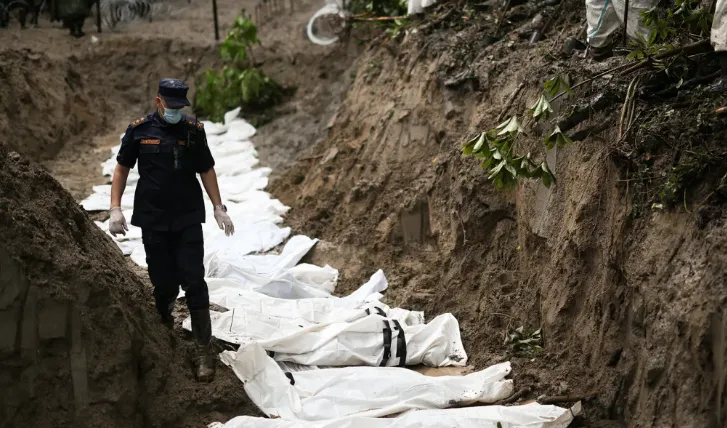 Petugas Nepal berdiri di lokasi kuburan massal korban banjir bandang.