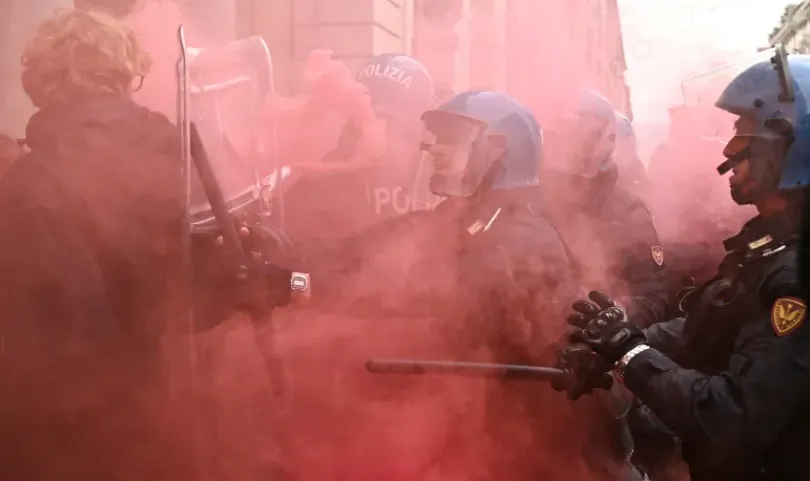 Para mahasiswa berhadapan dengan petugas polisi Italia di Turin pada 30 Oktober selama demonstrasi sebagai bagian dari aksi mogok dan protes nasional.