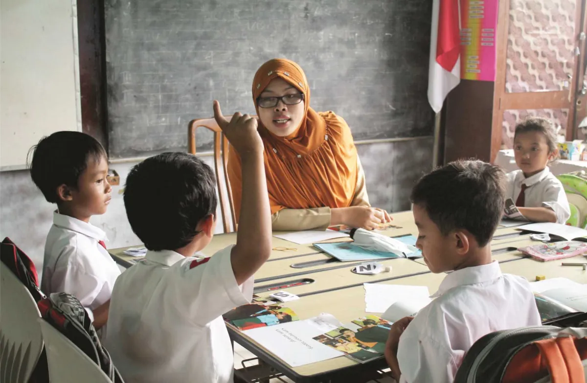 Ilustrasi guru memberi bimbingan pada siswa agar berani menulis.