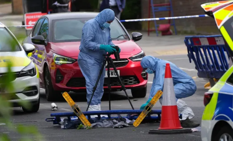 Petugas polisi forensik memotret lokasi kejadian di mana dua orang ditikam dalam serangan anti-Semit pada bulan April di London.