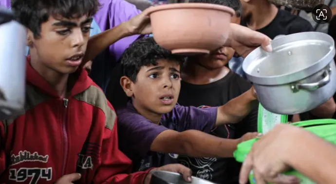 Warga Palestina, termasuk banyak anak, berkumpul untuk menerima makanan hangat selama distribusi bantuan makanan di kamp pengungsi Nuseirat di Jalur Gaza tengah pada 8 Oktober 2026.