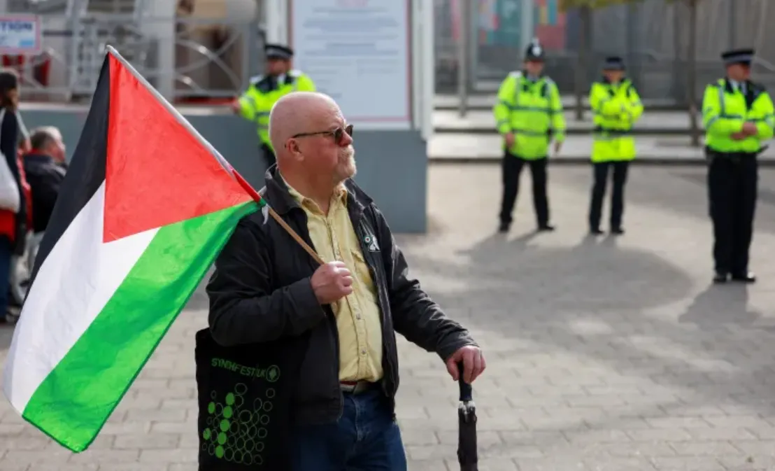 Seorang pria memegang bendera Palestina selama protes aksi Palestina pada September 2026.