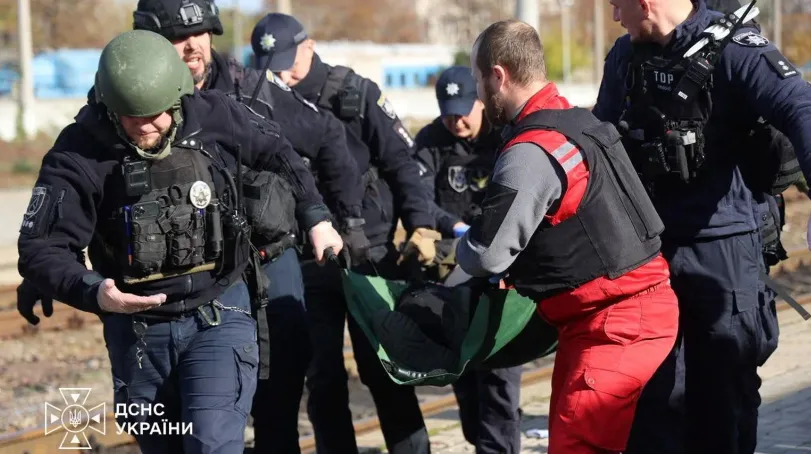 Seorang paramedis dan petugas polisi membawa seseorang yang terluka di stasiun kereta api selama serangan pesawat tak berawak Rusia di Dnipro pada hari Kamis.