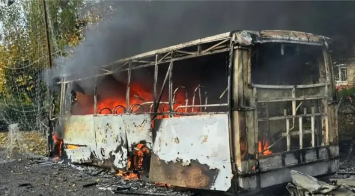 Kerangka logam bus yang terbakar bersama dengan puing-puing.